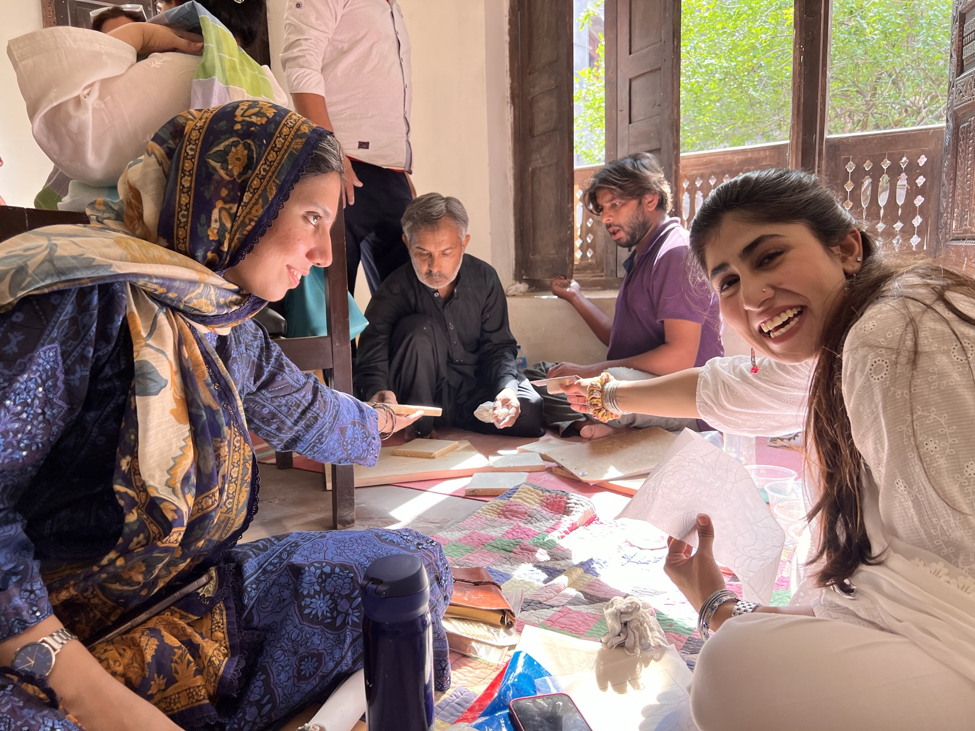 Hands-on Naqqashi practice with Usman Saeed and Saamia Vine: scaling and painting the Nargis motif on wet plaster.