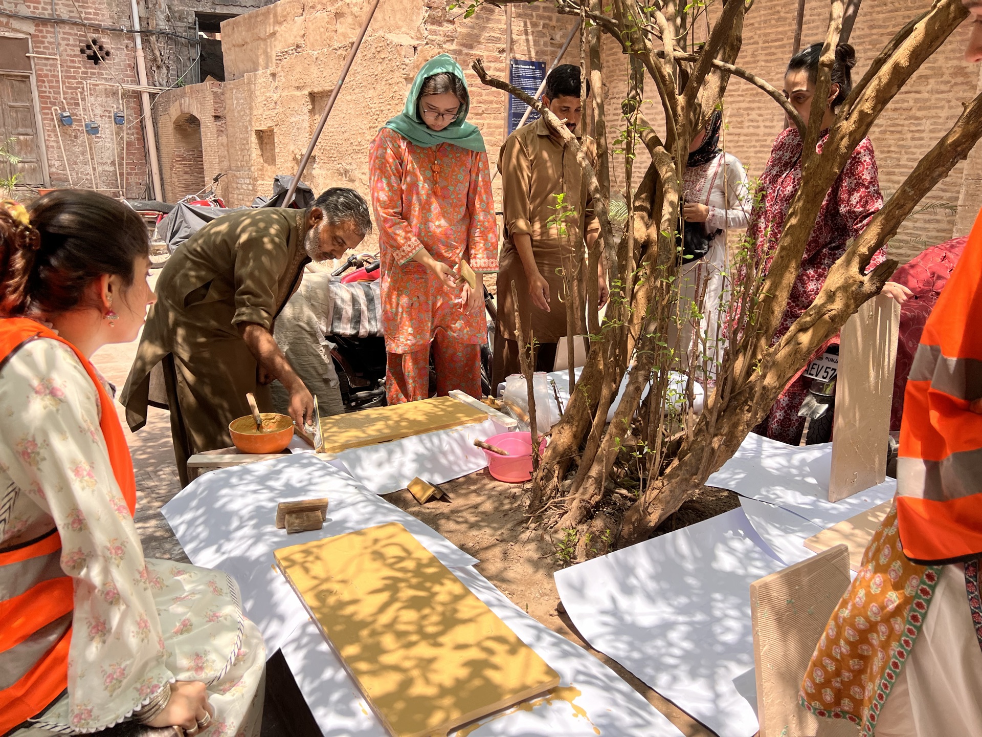 Hands-on Naqqashi practice with Usman Saeed and Saamia Vine: scaling and painting the Nargis motif on wet plaster.