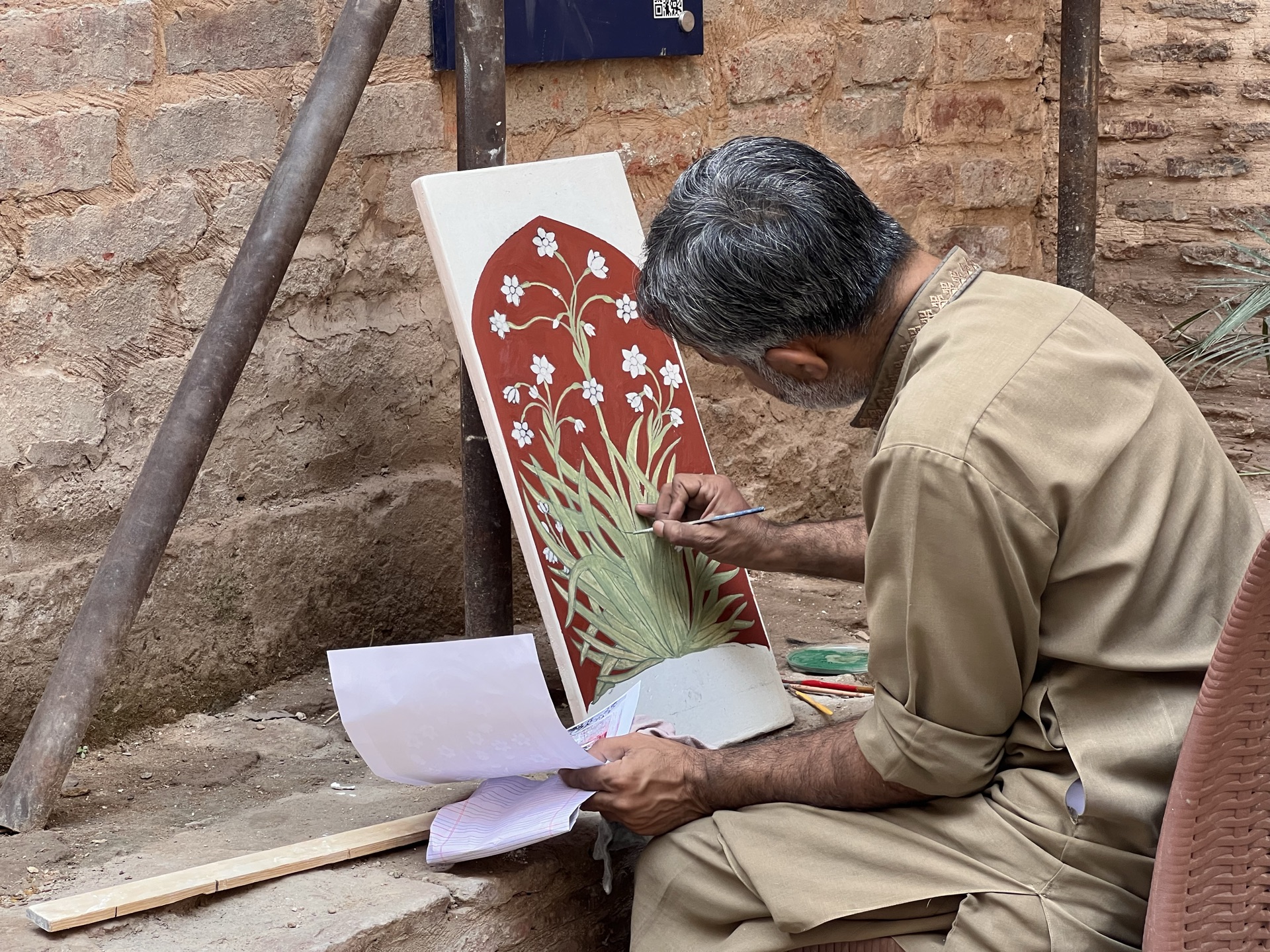 Hands-on Naqqashi practice with Usman Saeed and Saamia Vine: scaling and painting the Nargis motif on wet plaster.
