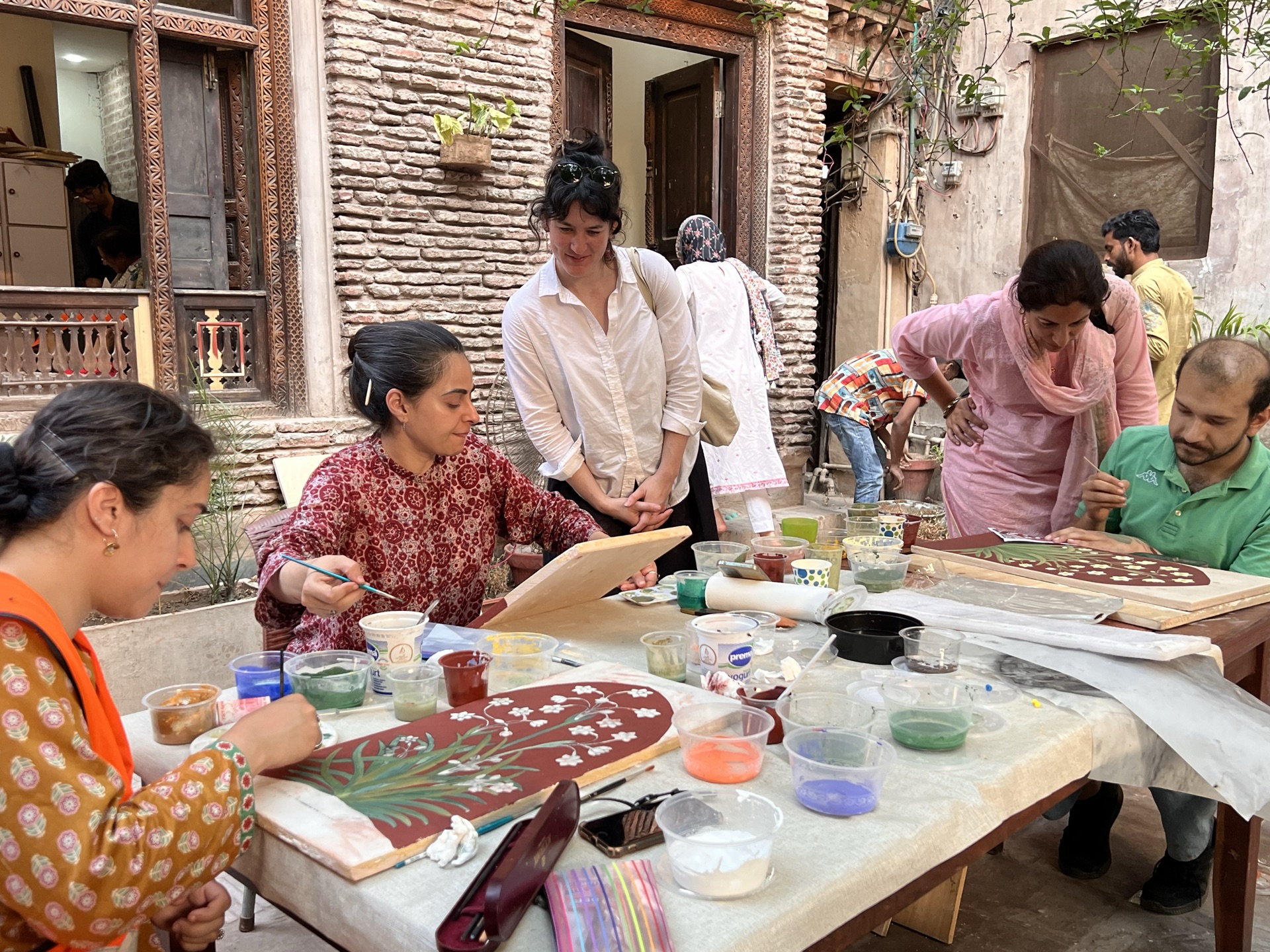 Hands-on Naqqashi practice with Usman Saeed and Saamia Vine: scaling and painting the Nargis motif on wet plaster.
